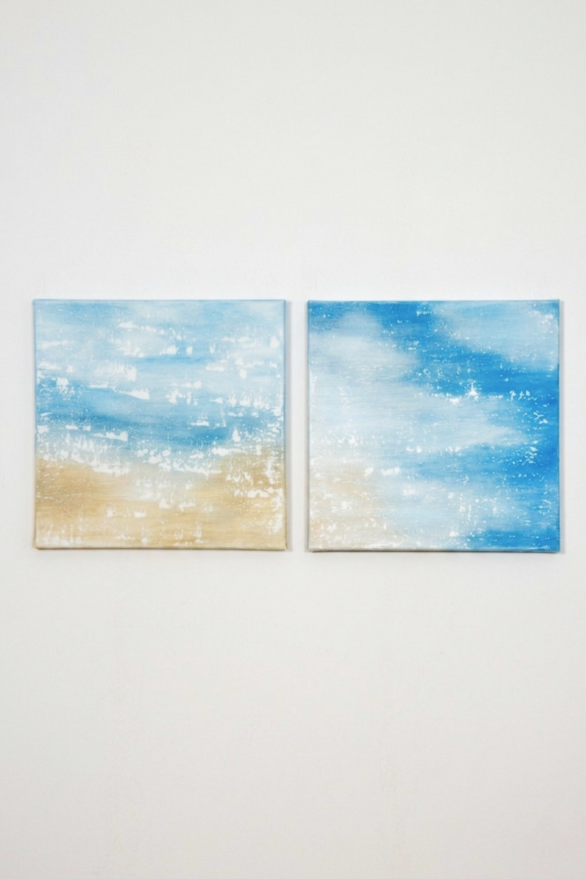 A professional diptych titled "Endless Shore" consisting of two square canvases. The abstract textured paintings feature a serene coastal scene with a bright blue sky, white foamy waves, and golden sandy shores. The style is minimalist and airy, with visible expressive brushstrokes and texture. Both panels are perfectly square.